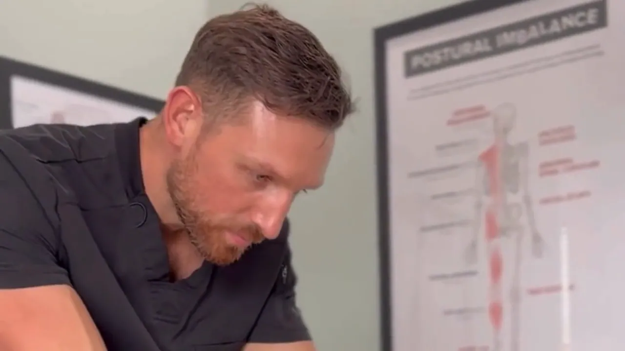 Reviewing a postural findings chart in the treatment room at Spinal Solutions in St. Augustine