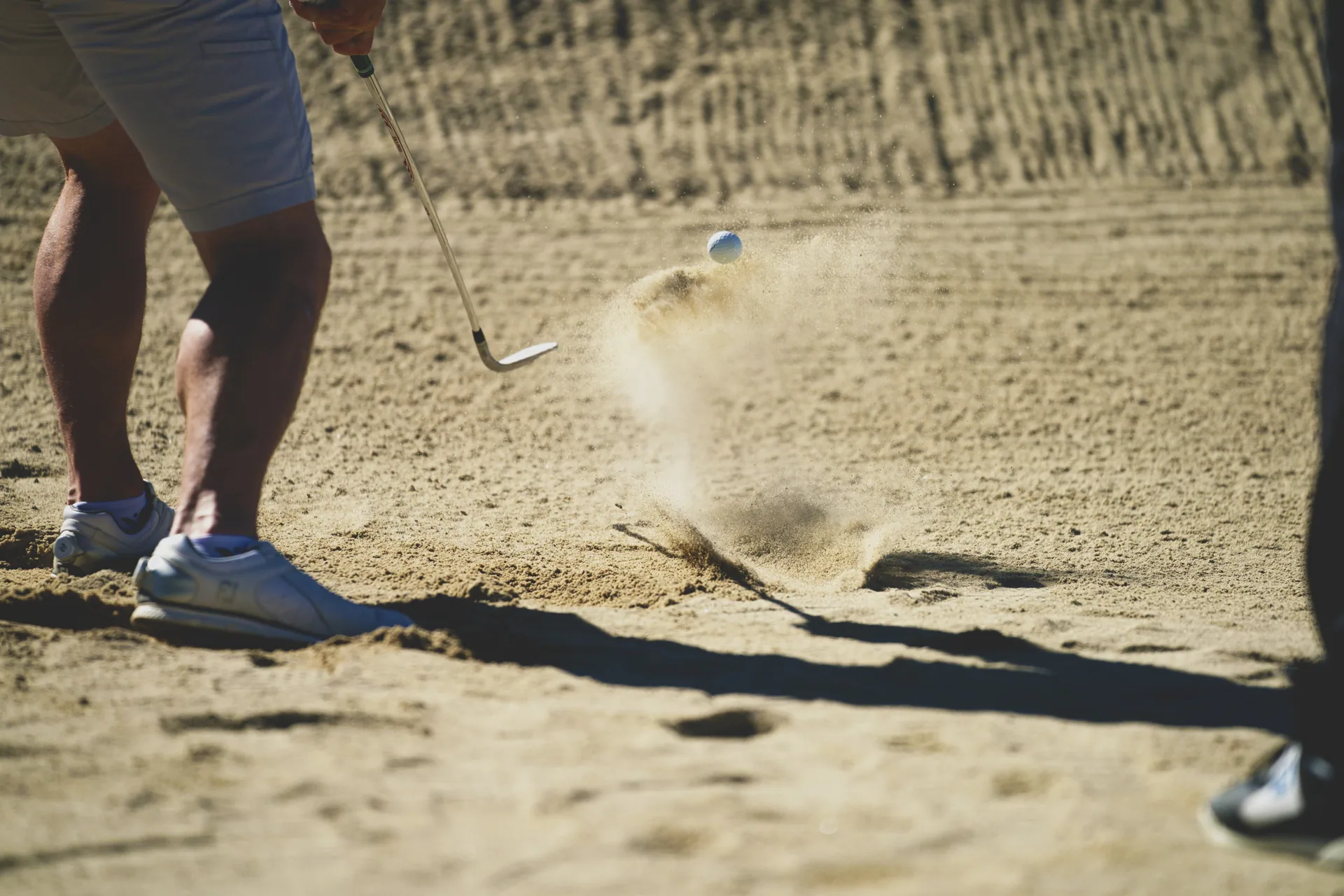 Golfer playing a bunker shot on a course near St. Augustine